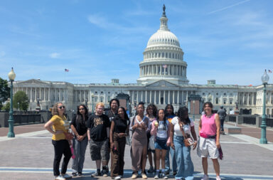 Eleven members of the Action Research Team youth and adults standing in front of the Capitol building in Washington DC.